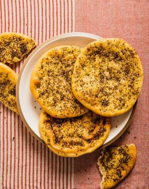 za'atar flatbread on a plate; torn pieces of flatbread lie next to the plate